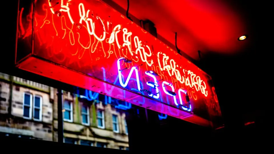 Red and blue neon signs glowing against a black night