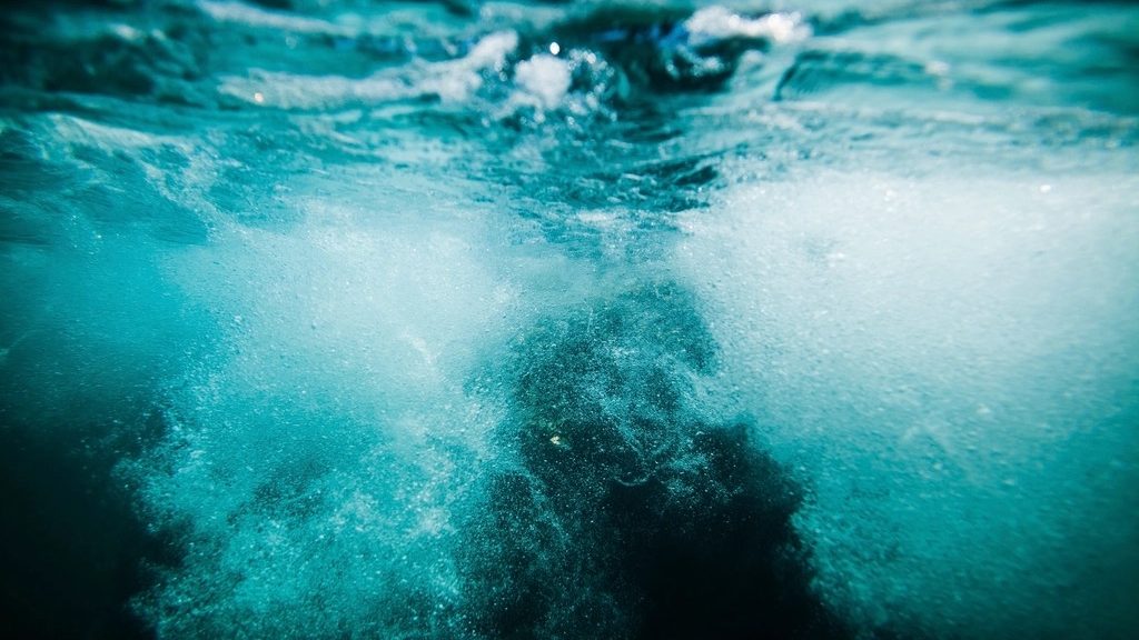 Churning turquoise sea water with white foam