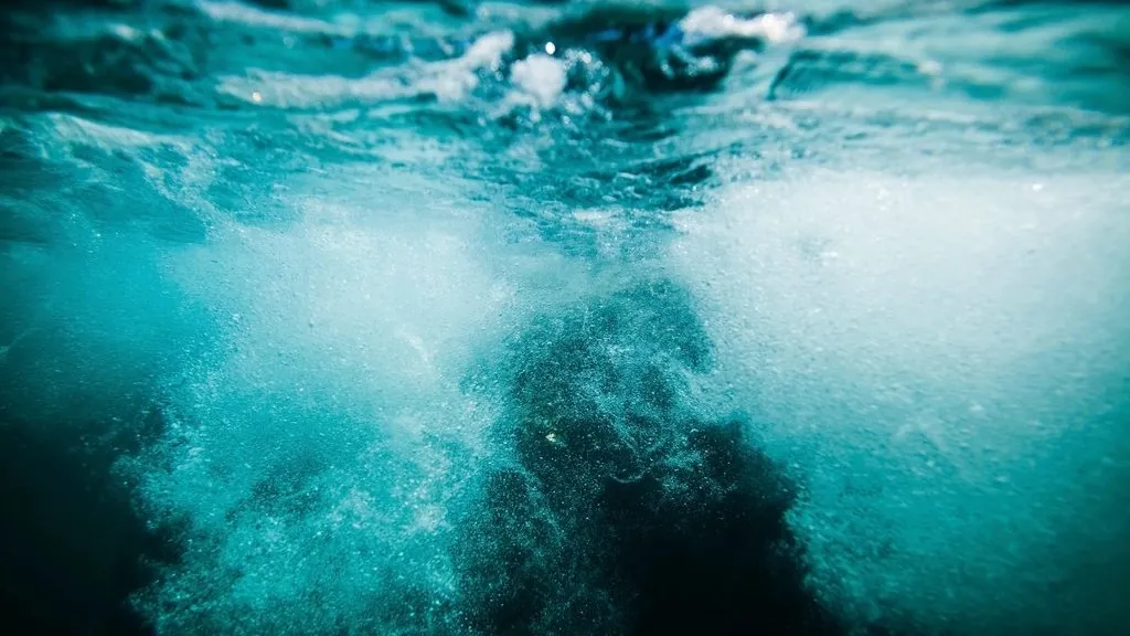 Churning turquoise sea water with white foam